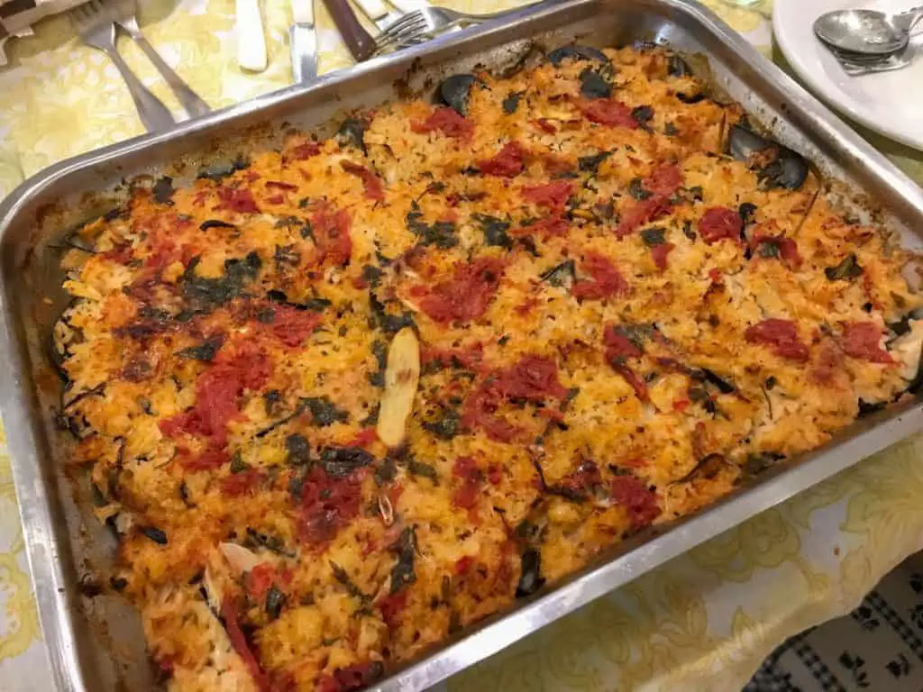Baked Rice in a Baking Pan with Mussels, Potatoes, Onions and Tomatoes