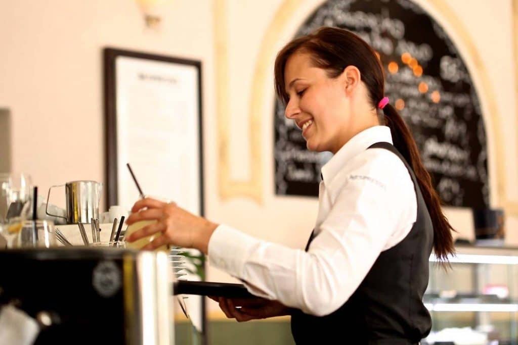 Woman waiter wearing a white shirt and holding a menu