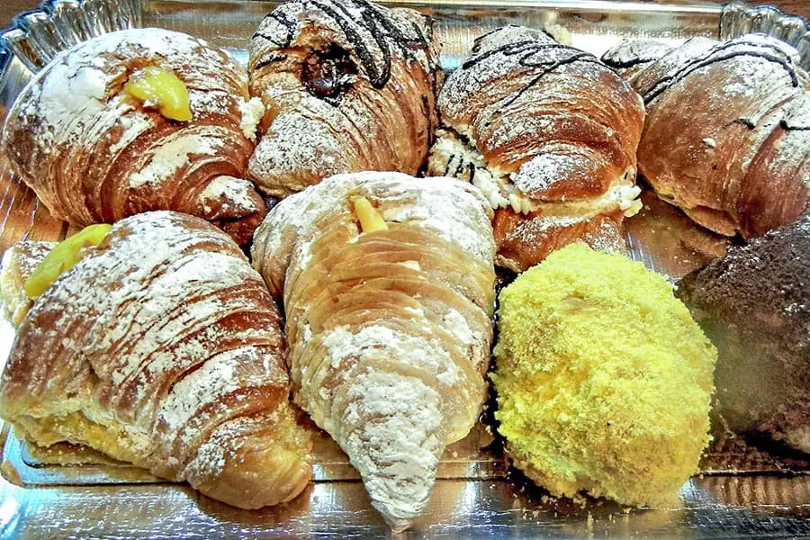Croissants with powdered sugar and cream